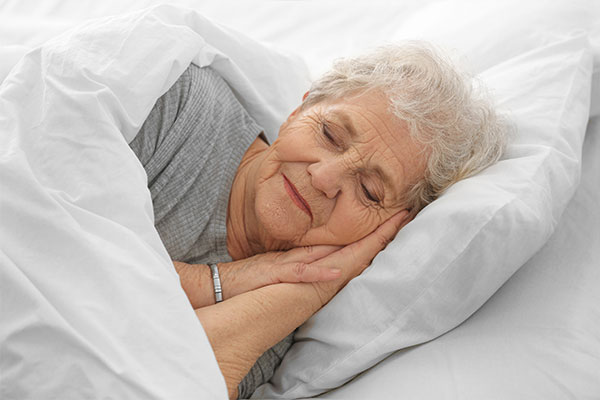 Senioren- & Pflegeheime - Bettwäsche und Frotteewäsche. Hier im Bild: eine Dame, die ihren Schlaf in frischer Bettwäsche genießt.
